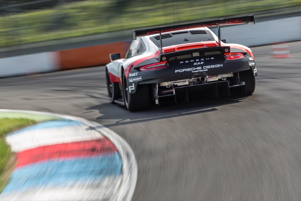 Vue arrière d'une Porsche 911 RSR de compétition en pleine accélération sur circuit
