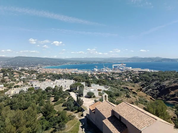 Vue aérienne ou perspective du port et de la côte de La Ciotat avec ses caractéristiques visuelles distinctives (les calanques, le littoral méditerranéen, les installations portuaires). L'image doit montrer clairement le contexte géographique côtier varois sans personnes ni véhicules au premier plan, permettant d'identifier visuellement la localisation de La Ciotat comme zone d'intervention de l'atelier.