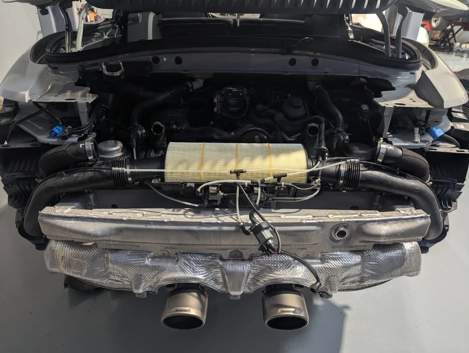 mécanicien automobile remplaçant et déversant de l'huile à moteur dans un moteur automobile à un poste de maintenance