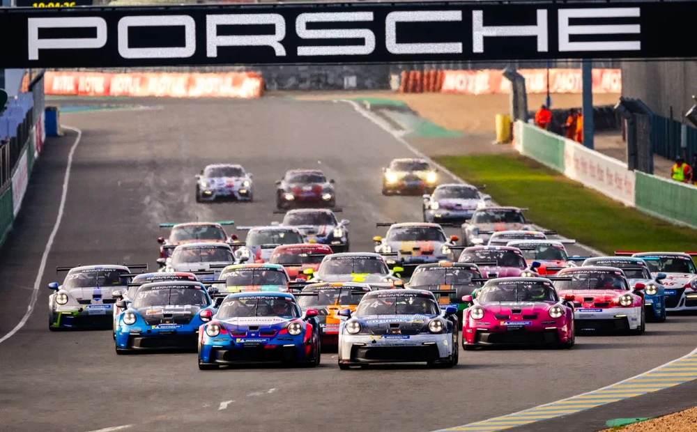 Porsche 911 GT3 Cup (992) violette, numéro 91, en pleine action sur circuit mouillé sous forte pluie